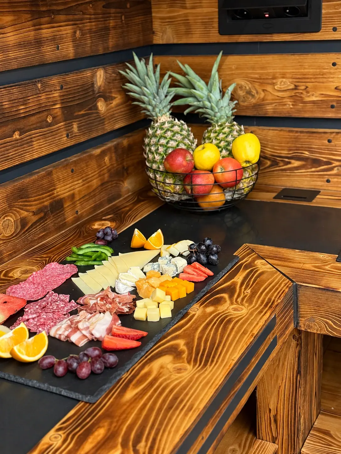 A breakfast board of cheeses, cured meats and fresh fruit